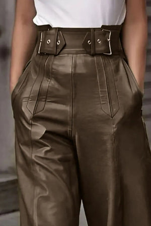 Brown leather pants with a belt worn by a person against a neutral background