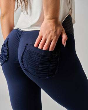 Navy blue leggings with textured design worn by a person on a plain background