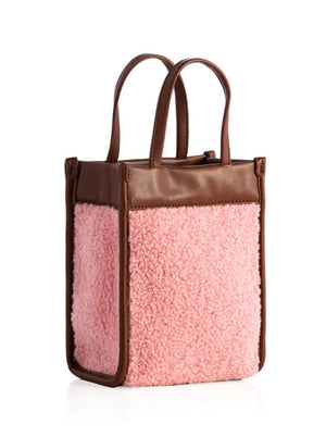 A pink sherpa mini tote cross-body bag with vegan leather accents, viewed from the front.