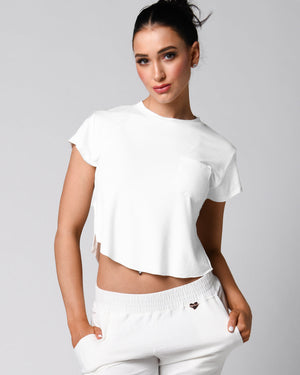 A person wearing a pink t-shirt with a front right pocket, paired with matching pink shorts.