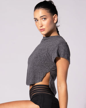 A person wearing a pink t-shirt with a front right pocket, paired with matching pink shorts.