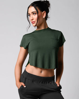 A person wearing a pink t-shirt with a front right pocket, paired with matching pink shorts.