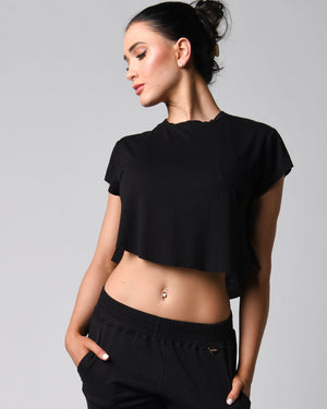 A person wearing a pink t-shirt with a front right pocket, paired with matching pink shorts.