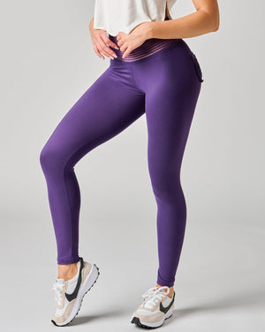 Purple leggings worn by a person on a gray background