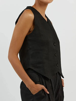 Person wearing a black vest and pants on a plain background