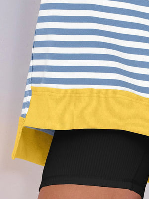 Close-up of a striped shirt with yellow trim on a plain background