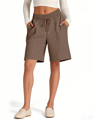 Brown shorts worn by a person on a white background