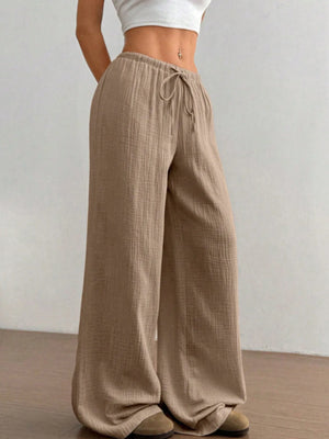 Beige wide-leg pants worn by a person on a plain background