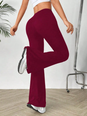 Person wearing maroon pants and white sneakers on a plain background