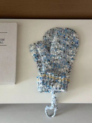 Knitted baby bootie with blue and gray pattern on a white surface