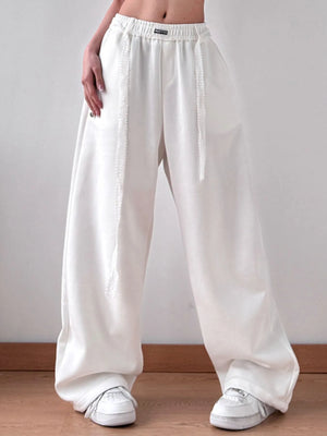 White wide-leg pants worn by a person on a plain background