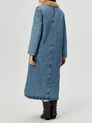 Person wearing a long blue denim coat on a white background