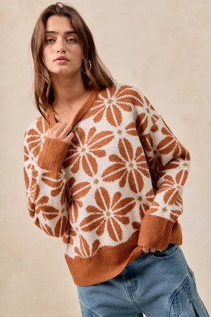 Woman wearing a patterned sweater with a neutral background