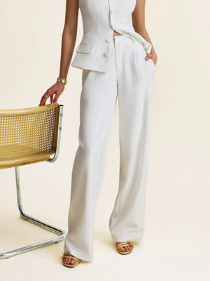 Person wearing a white suit with wide-leg pants on a beige background