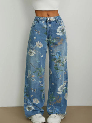 Blue floral jeans worn by a person on a plain background