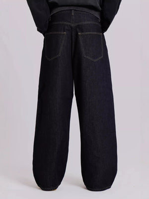 Black wide-leg jeans worn by a person on a light gray background