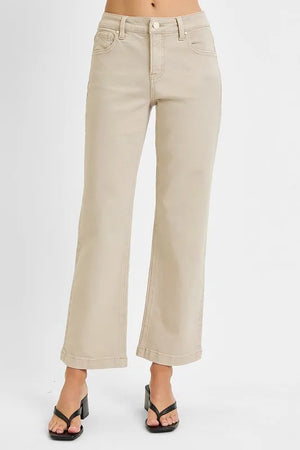 Beige wide-leg jeans worn by a person on a white background