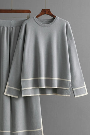 Gray outfit with white trim on a hanger against a gray background
