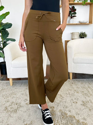 Person wearing brown wide-leg pants in a living room setting
