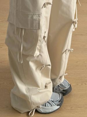 Beige pants with drawstrings worn by a person on a wooden floor