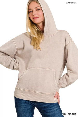 Woman wearing a beige hoodie with 'Acid Wash' text on a white background