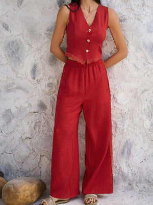 Person wearing a red jumpsuit against a textured stone wall.