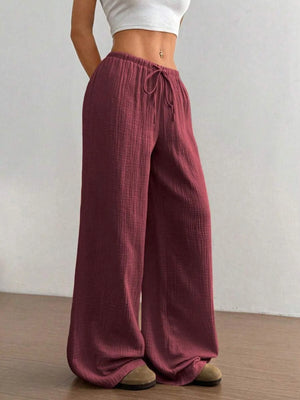 Maroon wide-leg pants worn by a person on a plain background