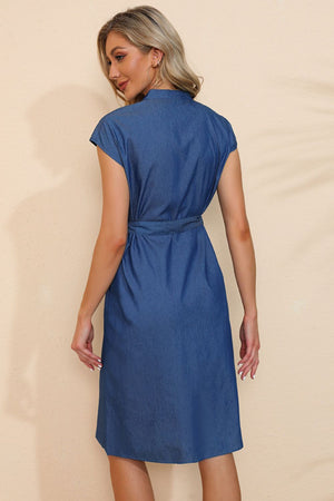 Woman wearing a blue dress against a beige background