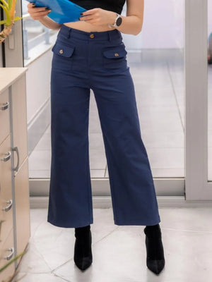 Person wearing blue high-waisted pants indoors.