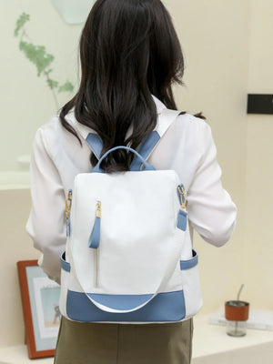 Person wearing a white and blue backpack indoors