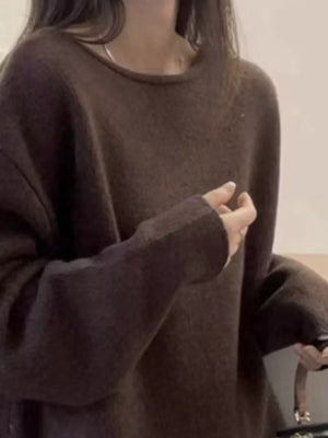 Person wearing a brown oversized sweater in a minimal indoor setting