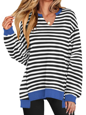Black and white striped long-sleeve top with blue accents worn by a person on a white background