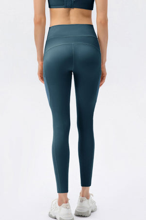 Person wearing teal leggings on a white background