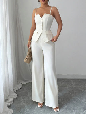 Woman wearing a white outfit with a blazer and wide-leg pants in a minimalistic setting.