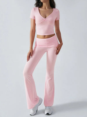 Person wearing a pink outfit with a top and pants on a light gray background