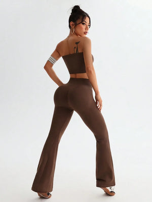 Woman wearing a brown outfit with flared pants on a white background
