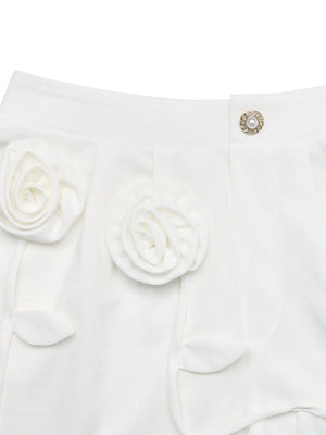 White garment with floral details and a decorative button on a white background