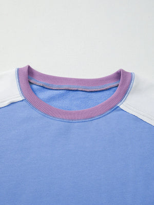 Close-up of a blue shirt with a purple collar on a light gray background