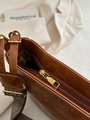A view of the zipper on brown PU Leather Adjustable Strap Crossbody Bag with Pouch