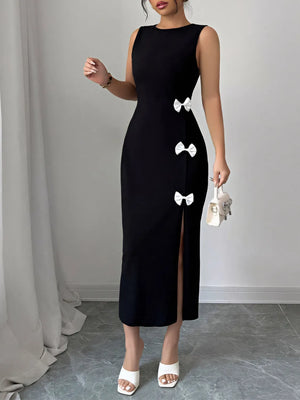Black dress with white bow details worn by a model against a plain background
