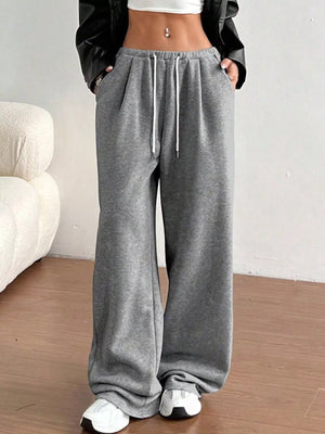 Person wearing gray sweatpants with a white background