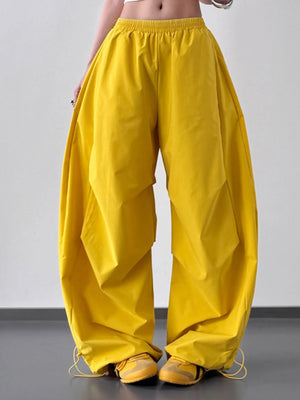 Yellow wide-leg pants worn by a person on a plain background