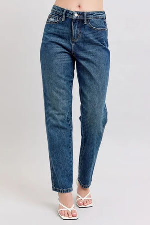 Blue jeans worn by a person on a plain background