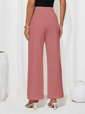 Person wearing pink wide-leg pants on a white background