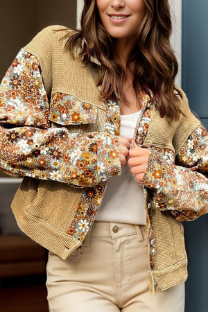 Woman wearing a floral embroidered jacket with a neutral background