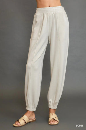 Beige pants worn by a person on a gray background