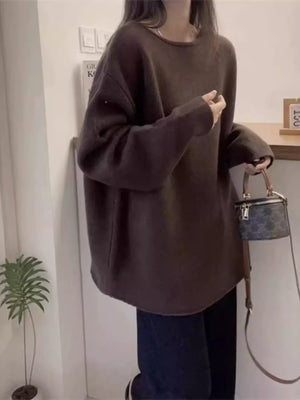 Person wearing a brown oversized sweater in an indoor setting