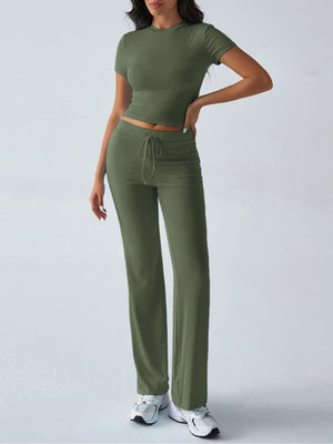 Woman wearing a green outfit with a top and pants on a white background