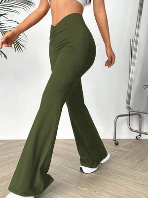 Person wearing green flared pants in a minimal indoor setting