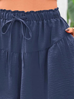 Navy blue pants with a tie waist being worn by a person.